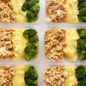 Frango desfiado (120g), purê de raízes (150g), brócolis (50g) – prato sem glúten/lactose